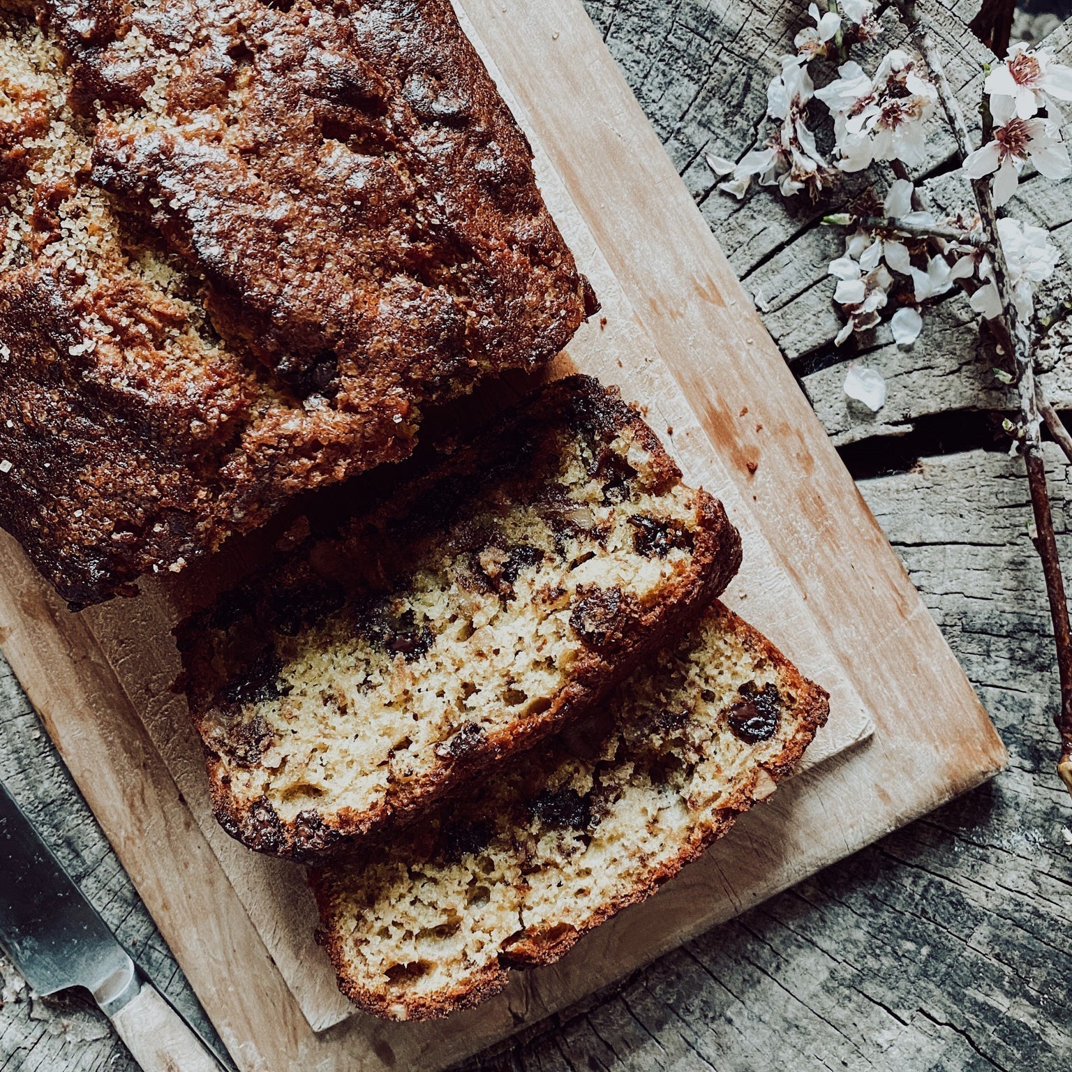 Freshly cut banana, chocoalte & walnut loaf on a wooden board 