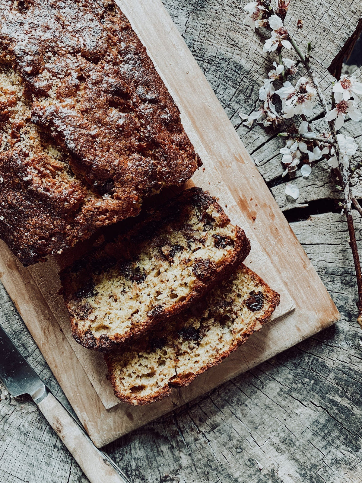 Freshly cut banana, chocoalte & walnut loaf on a wooden board 